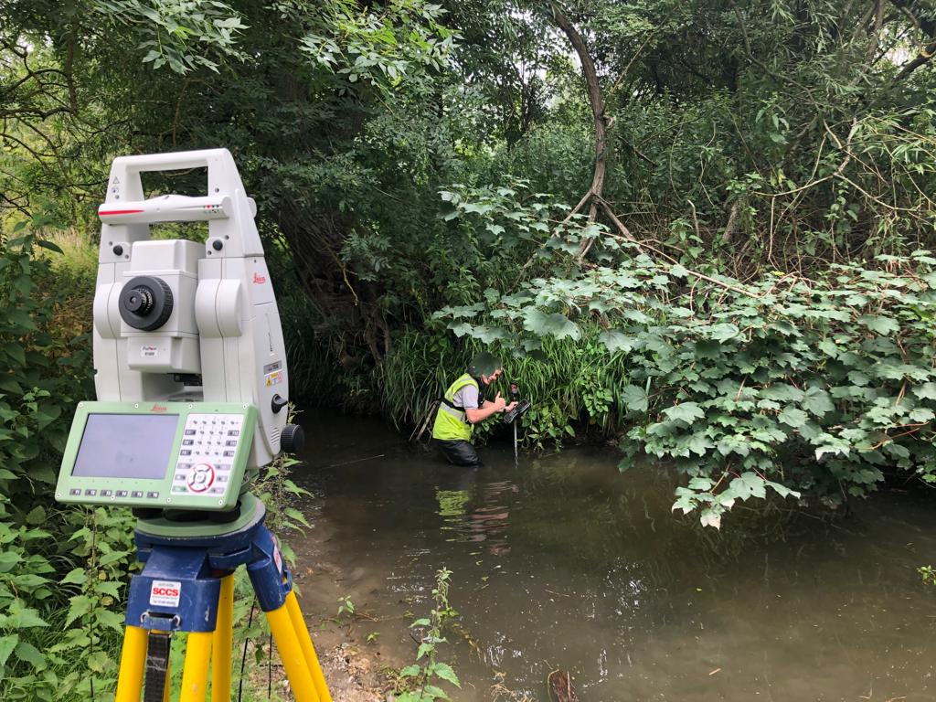 Total station surveying tool measuring prism operated by land surveyor in river
