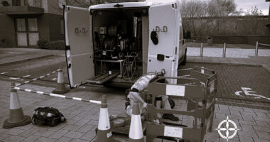 Image showing the open back of a CCTV van, with barriers around a manhole for drain inspection works
